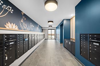 A hallway with mailboxes on the side and a flower painted on the wall